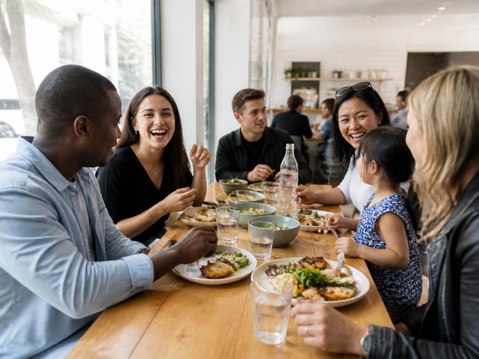 Guests sharing fire-grilled chicken and BBQ at a BRAVA restaurant